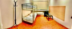 a room with two bunk beds in a room with a table at Valka Hostel in Valka