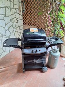 a grill sitting on a patio next to a trash can at Casa Vacanza Olivegrove in Massa Lubrense