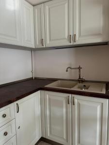 a kitchen with white cabinets and a sink at CH Exclusive Copou in Iaşi +18 photos