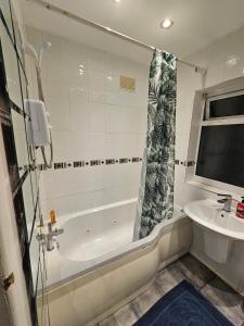 un baño con bañera y lavabo en London Serviced Accommodation x RM10 x DM 4 Weekly x Monthly Deals x Sleeps 10 x FREE Parking x FREE Wifi E, en Dagenham