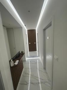 a hallway with white walls and a staircase with a mirror at Emerald Rooms in Naples