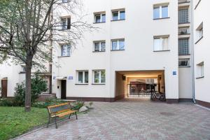 a bench in front of a white building at Patro Apartament 2 Wrocław Centrum in Wrocław