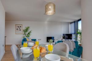 a dining room with a glass table with orange juice at Blonk Street I Quarter Apartment in Sheffield