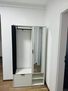 a glass cabinet with a mirror next to a wall at Milan Luxury Apartaments VII-Târgu Mureș#Maurer Residence in Târgu-Mureş +1 photo