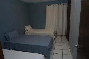 a small room with two beds and a window at Habitación con tres camas in Tonalá
