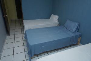 two beds in a room with blue walls at Habitación con tres camas in Tonalá
