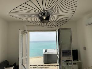 Una gran lámpara de techo en una habitación con vista al mar. en La Villa di Nonna Pina, en Balestrate