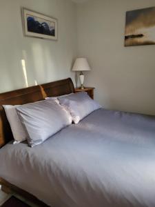 a bed with white pillows sitting in a bedroom at 75 Park Prewett in Basingstoke