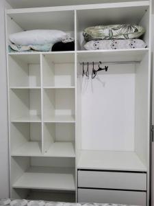 a white closet with white shelves in a room at Apto Belle Residencial Ilha Bela in Passo de Torres
