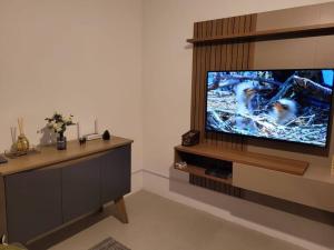 a living room with a large flat screen tv at Apto Belle Residencial Ilha Bela in Passo de Torres