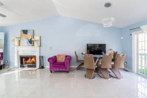 ein Wohnzimmer mit einem lila Stuhl und einem Kamin in der Unterkunft Amazing, cozy & warm family homeWarm and cozy home in Lithonia