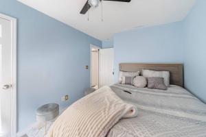 ein Schlafzimmer mit einem großen Bett mit blauen Wänden in der Unterkunft Amazing, cozy & warm family homeWarm and cozy home in Lithonia
