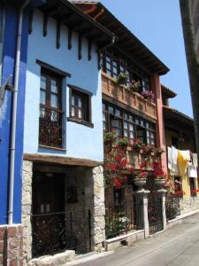ポオ・デ・リャネスにあるLa Milarinaの花箱と窓のある青い建物