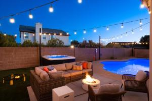 une terrasse arrière avec un canapé et un foyer extérieur dans l'établissement Glendale Nights - Pool Hot Tub Put Put Foosball, à Glendale