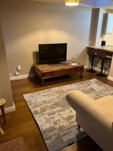 a living room with a television and a coffee table at Garden Flat near train station in Salisbury