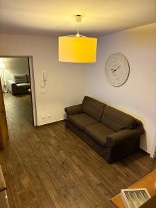 a living room with a couch and a clock on the wall at Marina Mondello House comfort in Mondello