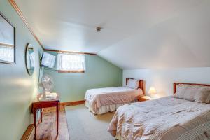 a bedroom with two beds and a table with a fan at Penn Yan Vacation Rental Near Seneca and Keuka Lakes in Penn Yan