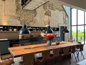 a dining room with a wooden table and chairs at Les Fromentaux in Poisson