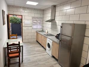 a kitchen with a refrigerator and a washing machine at Italica in Santiponce