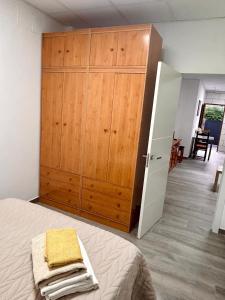 a bedroom with a large wooden cabinet next to a bed at Italica in Santiponce