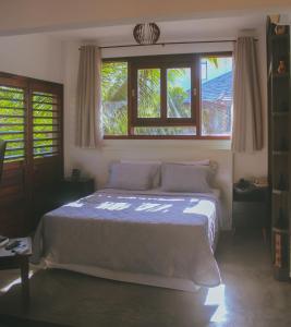 a bedroom with a large bed with two windows at Naquela Casa Jericoacoara in Jericoacoara +23 photos