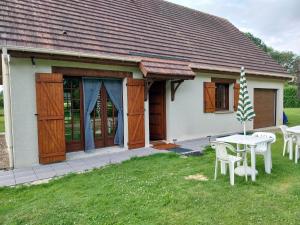 a house with a table and chairs in the yard at maison du roumois 1 chambre in Berville-en-Roumois