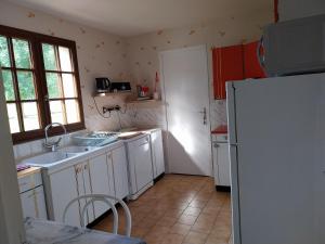 a kitchen with white cabinets and a white refrigerator at maison du roumois 1 chambre in Berville-en-Roumois +5 photos