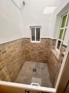 a shower in a room with a brick wall at Italica in Santiponce