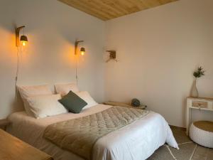 a bedroom with a large white bed with two pillows at Lodge évasion Lot & Dordogne in Masclat