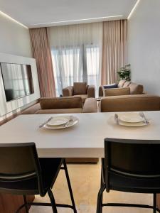 a living room with a large white table and chairs at Damac Apartment شقة مع جاكوزي بإطلالة بحرية in Jeddah