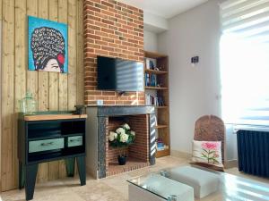 a living room with a fireplace and a tv at "Le 35" Maison rénovée avec jardin proche centre in Lamotte-Beuvron