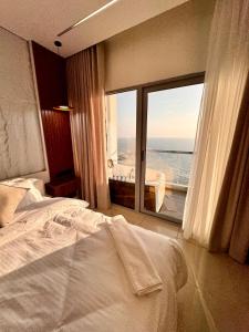 a bedroom with a bed and a large window at Damac Apartment شقة مع جاكوزي بإطلالة بحرية in Jeddah