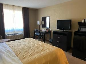 a hotel room with a bed and a television at Quality Inn Harlan in Harlan