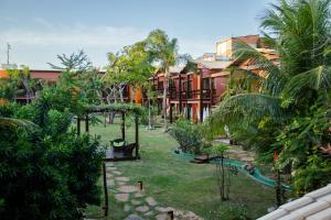 a garden with trees and buildings in a city at Naquela Casa Jericoacoara in Jericoacoara