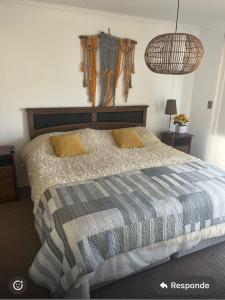 a bedroom with a bed with a blue and gray comforter at Quebrada de la Candelaria III in Algarrobo