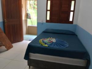 a bedroom with a bed with a blue bedspread at Chales do porto in Ilha de Boipeba +15 photos