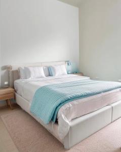 a white bed with a blue blanket on it at Jumet 242 A Bruxelles-Charleroi-airport in Charleroi