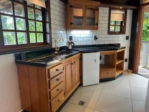 a kitchen with a sink and a refrigerator at Minas Em Marambaia in Rio de Janeiro