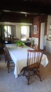 einen Tisch mit einem weißen Tischtuch und Stühlen in der Unterkunft Casa Mazensio in Mar del Plata