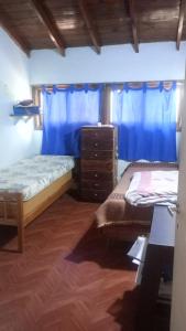 zwei Betten in einem Zimmer mit blauen Vorhängen in der Unterkunft Casa Mazensio in Mar del Plata