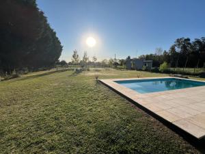 a swimming pool in the middle of a grass field at El Buen Criollo in San Miguel del Monte