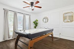 a living room with a pool table and a ceiling fan at Modern Comforts & Classic Charm w Pool 5BD in Saginaw