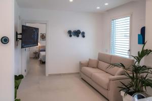 a living room with a couch and a flat screen tv at Appartamenti Aurelia 89 in Nardò