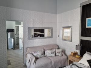 a living room with a couch and a mirror at Twelveon1st in Cape Town