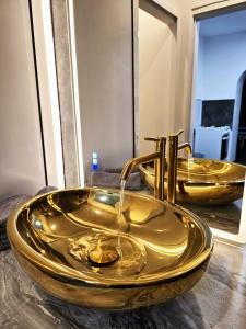 a gold sink in a bathroom with two mirrors at Rentcenter79 in Donawitz
