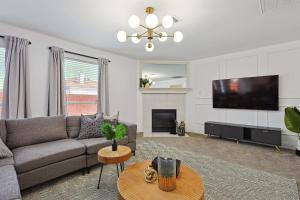 een woonkamer met een bank en een flatscreen-tv bij Modern Comforts & Classic Charm w Pool 5BD in Saginaw