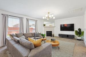 a living room with a couch and a tv at Modern Comforts & Classic Charm w Pool 5BD in Saginaw