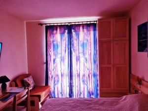 ein Schlafzimmer mit Fenster mit Bett und Schreibtisch in der Unterkunft Студио PANORAMA MOUNTAIN, до ски писта Пампорово-Стойките in Stoykite