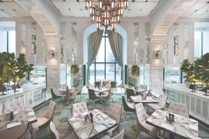 a restaurant with tables and chairs and a chandelier at Crown Towers Melbourne in Melbourne