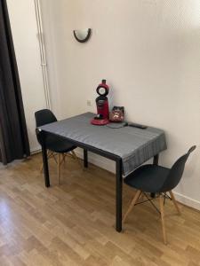 a table with two chairs and a blender on it at Studio central cosy proche gare in Ruffec